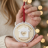 Person holding a decorative ornament with 'Our first year in our new home' text and a house symbol.
